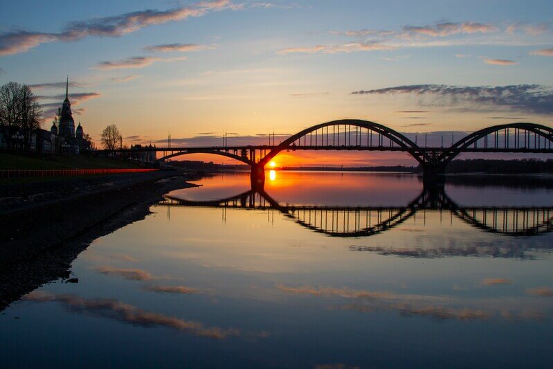 Закат над Рыбинским мостом через реку Волгу в городе Рыбинске Ярославской области.